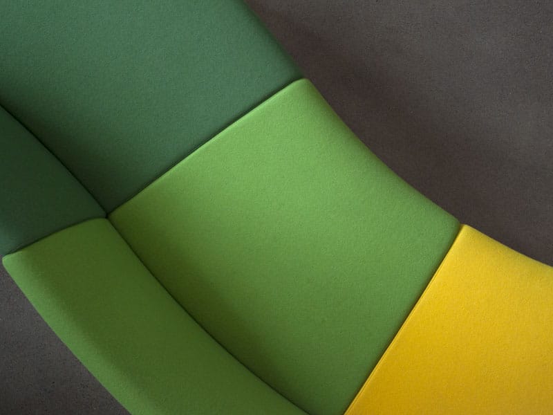 Detail of a curved sofa in green and yellow,  shot from above